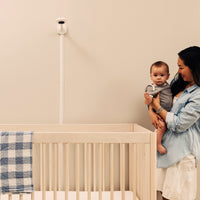 nanit pro baby monitor + wall mount mounted on wall looking at crib while mom holds baby next to crib #mount_wall mount