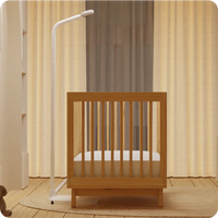 baby crib in room with nanit pro baby monitor floor stand on side of crib