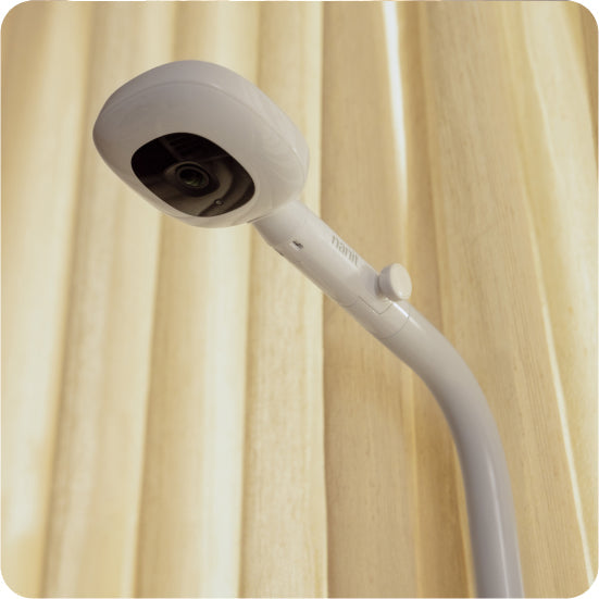 Pro Baby Monitor + Floor Stand on a beige curtain background